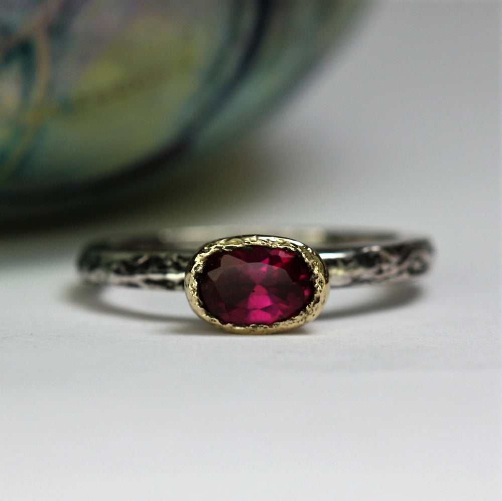 Oval Tourmaline encased in a 9ct gold setting oxidized ring band