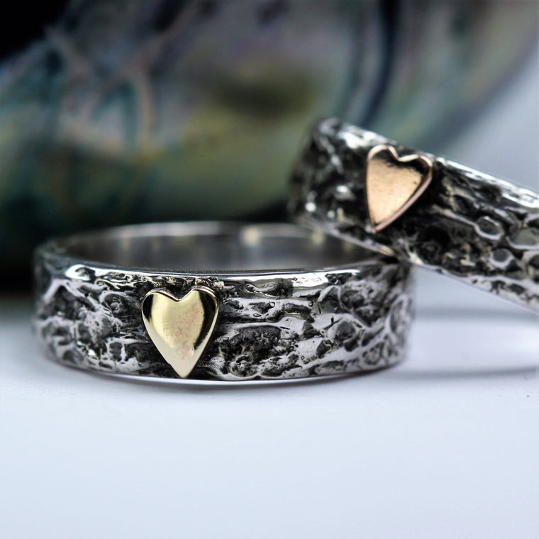 wide silver textured ring featuring a 9ct gold heart and oxidized  