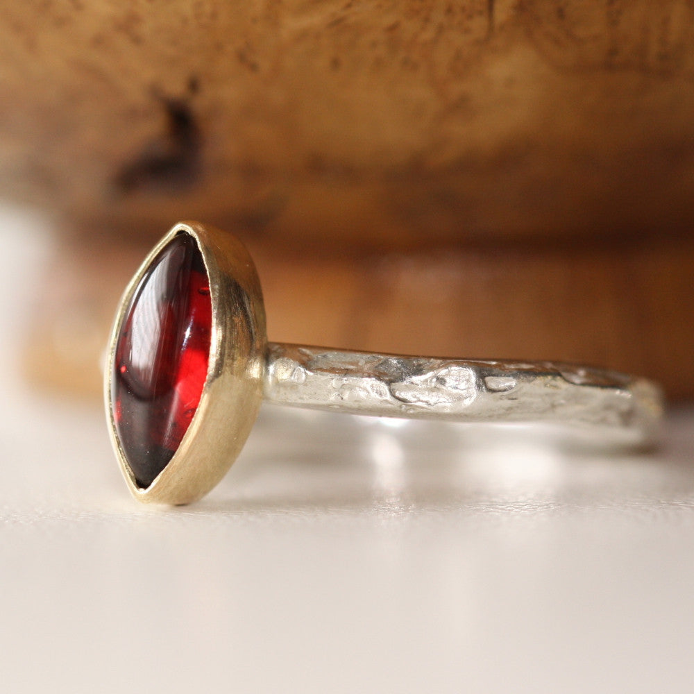 Slim textured ring band shown with a gold setting featuring a marquise Garnet gemstone