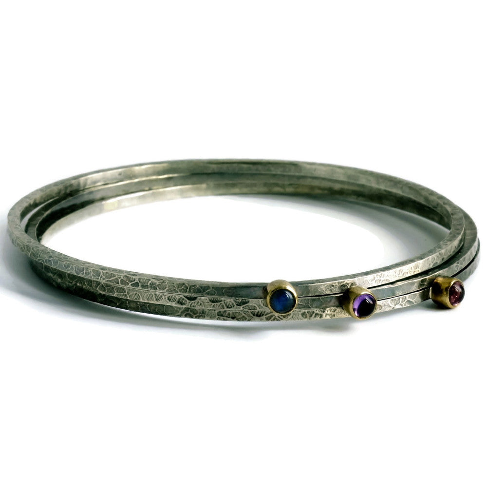 a stack of skinny blossom rustic silver and gold bangles with tourmaline, amethyst and labradorite