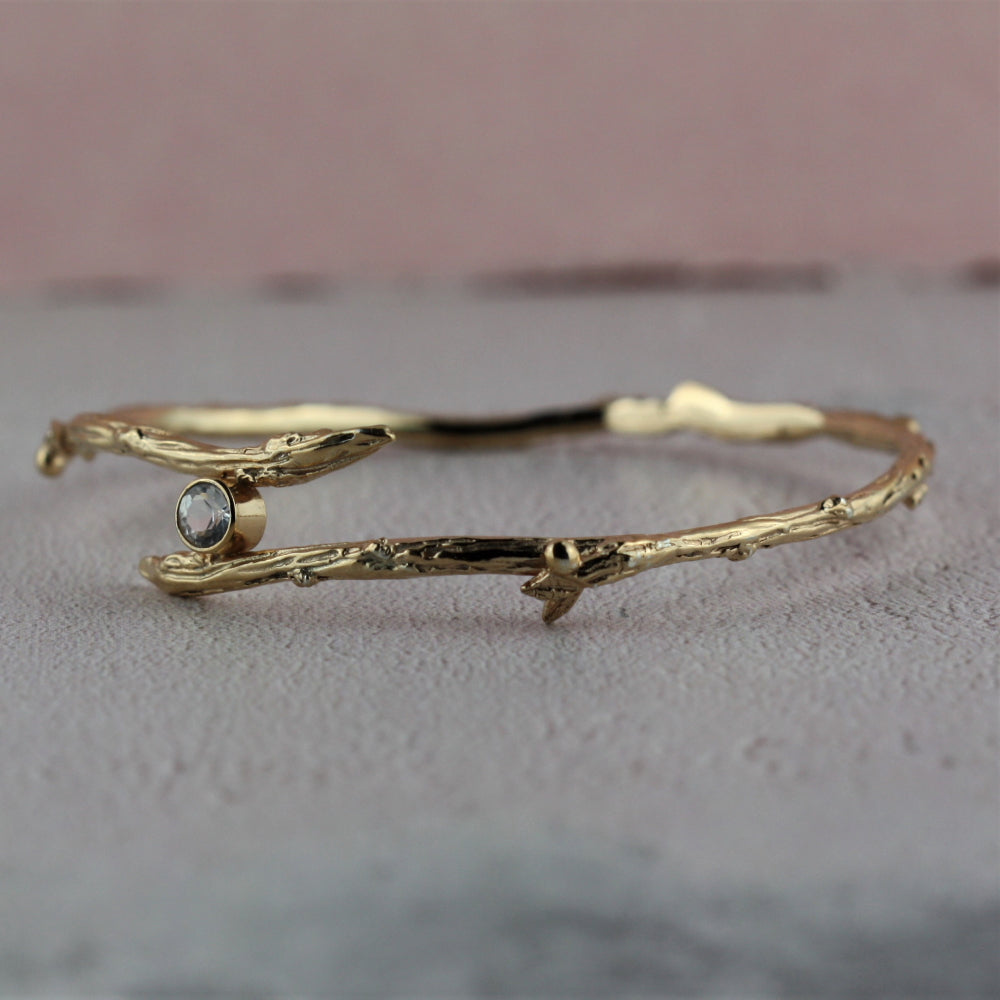 yellow gold twig bangle and white Topaz 